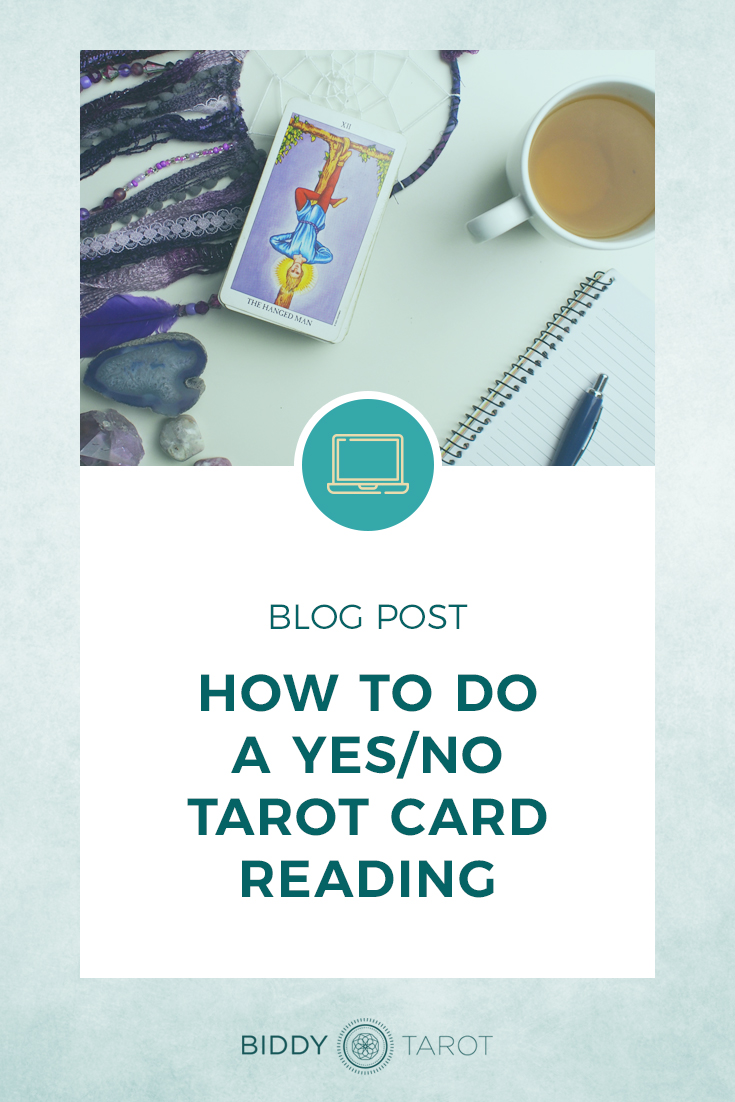 How to do a Yes/No Tarot Card Reading | Biddy Tarot | The Hanged Man from the Radiant Rider Waite Tarot Deck and a cup of tea with a dream catcher, along with a pen and notebook.